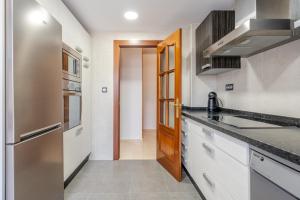 a kitchen with white cabinets and a wooden door at Pianista Apartment Granada by A3Rentals in Granada