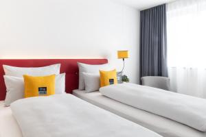 a hotel room with two beds and two lamps at the niu Franz in Vienna
