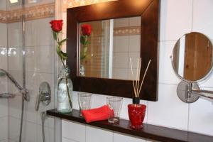 a bathroom with a mirror and a counter with glasses at Gästehaus Alpin in Oberstdorf