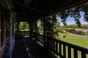 
a wooden deck overlooking a lush green field at Tzamenkomst River Lodge in Colesberg
