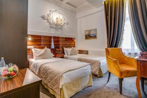 a hotel room with two beds and a chair at Sadovnicheskaya City Center in Moscow