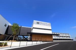 ein weißes Gebäude mit einer Straße davor in der Unterkunft Henn na Hotel Kansai Airport -Natural Hot Spring Spa- in Izumi-Sano