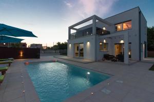 een huis met een zwembad ervoor bij Modern villa Nerina with private pool near Pula in Pula