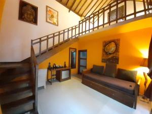 a living room with a couch and a staircase at Laguna Gili in Gili Trawangan