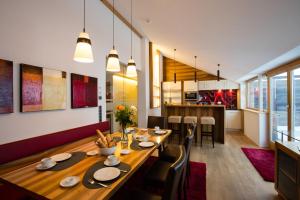 un comedor con una larga mesa de madera y sillas en Alpenappartement Bergkönig, en Warth am Arlberg