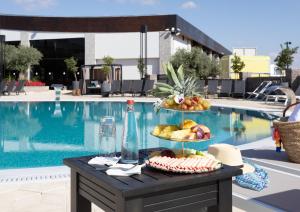 a tray of fruit on a table next to a pool at Dream Island Spa & Health Resort in Sede Yo‘av