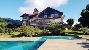 a large house with a swimming pool in front of it at Marabedda Gardens Resort in Rikillagaskada