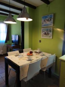 comedor con mesa y sillas blancas en Apartamentos La Iguana, en Hervás
