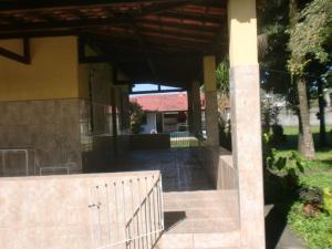 a porch of a house with a fence and a building at Casa Parada Modelo in Guapimirim