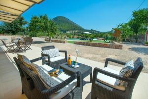 un patio con tavolo e sedie e vista di Owl Booking Villa La Rafal - Luxury Retreat with Mountain Views a El Port