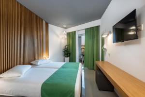 a hotel room with a large bed and a television at Zeus Hotel in Kefalos