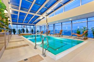 a swimming pool in a house with a view of the ocean at Qubus Hotel Kraków in Krakow