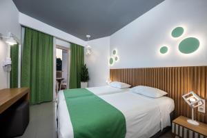 a bedroom with a large bed with green accents at Zeus Hotel in Kefalos