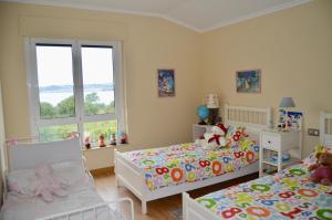 sypialnia z dwoma łóżkami i dwoma oknami w obiekcie Chalet al lado del mar entre Redes y El Raso w mieście Ares