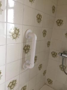 ducha con pared de azulejos blancos y mango de ducha en Foyleview Cottage, Moville en Moville