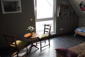 einen Tisch und Stühle in einem Zimmer mit Fenster in der Unterkunft Gästezimmer 10 min von der Altstadt entfernt in Hattingen