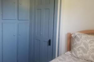 - une chambre avec une porte blanche à côté d'un lit dans l'établissement Old School House, à Hallowell