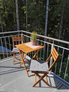 une table en bois et deux chaises sur une terrasse dans l'établissement Ferienwohnung Hirscher, à Annaberg-Lungötz