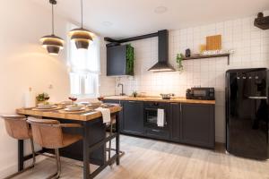 kuchnia z drewnianym stołem i czarnymi urządzeniami w obiekcie River Apartment in the heart of Bilbao EBI-01297 w mieście Bilbao