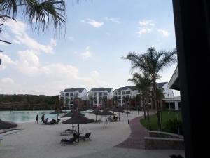 a resort with a pool and palm trees and buildings at The Blyde Crystal Lagoon Cologne3 in Greenview