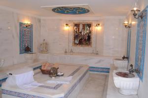 a large bathroom with a tub and a toilet and a tub at Marmaray Hotel in Istanbul