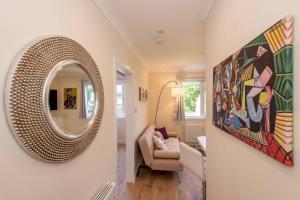 a hallway with a mirror and a living room at Pilmour Place - 30 Seconds to the Old Course! in St Andrews