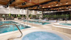 uma grande piscina interior com 2 banheiras de hidromassagem em Dream Island Spa & Health Resort em Sede Yo‘av