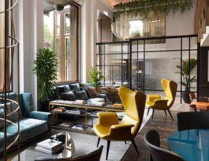 a living room with yellow chairs and a couch at The Athenaeum Hotel & Residences in London