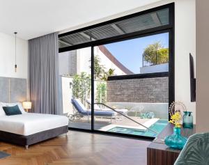 een slaapkamer met een bed en een zwembad bij Dream Island Spa & Health Resort in Sede Yo‘av