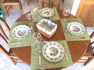 クアルテイラにあるQuarteira Beach Holidaysの皿とワイングラスが置かれた木製のテーブル