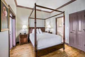 a bedroom with a canopy bed and a wooden floor at Water Street Hotel & Marina, Ascend Hotel Collection in Apalachicola