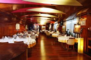 une salle à manger avec des tables et des chaises blanches dans l'établissement Hotel Anel, à Sofia