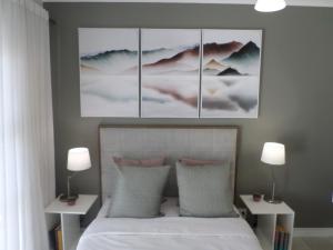 1 dormitorio con 1 cama con 4 cuadros en la pared en The Blyde Crystal Lagoon Cologne3 en Greenview