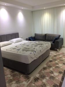 a bedroom with a large bed and a couch at Sunset Apart Otel in Oludeniz +39 photos