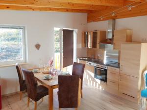 a kitchen with a wooden table and a dining room at Ferienwohnungen Raffler in Fieberbrunn