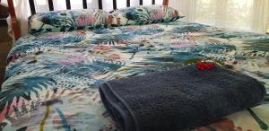 a bed with a colorful comforter with a blanket on it at Gap Creek Cabin in Ayton