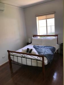 a bedroom with a bed with white pillows and a window at Stay in spacious, homely unit in prestigious area in Broadview