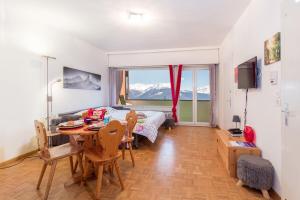 a living room with a bed and a table and chairs at L’Eperon Center Crans wonderful view in Crans-Montana