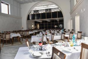 a dining room with white tables and chairs at Hotel Darina Tarnaveni in Tîrnăveni +14 photos