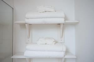 a stack of towels on a shelf in a bathroom at Colchester Town Duplex Apartment in Colchester +13 photos