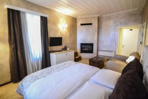 a bedroom with a white bed and a television at Guesthouse likoria in Arachova