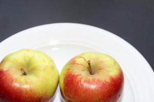 dos manzanas están sentadas en un plato blanco en Gästehaus Alpin en Oberstdorf