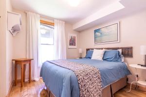 a bedroom with a blue bed and a window at Northview Swiss Style Chalet in Blue Mountains
