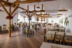 a dining room with tables and chairs and wooden beams at Hotel Darina Tarnaveni in Tîrnăveni