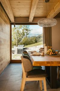 ein Esszimmer mit einem Tisch und einem großen Fenster in der Unterkunft Eco Chalet AstraMONTANA in Tolmin