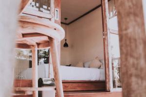 a bedroom with a bed with white sheets and a mirror at my house guest house in batumadeg