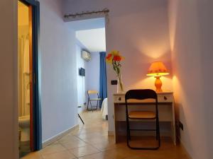 a room with a desk with a lamp and a vase of flowers at Luna Convento Copanello B&B in Stalettì