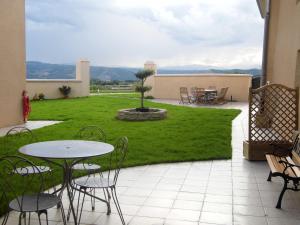 a patio with a table and chairs and a lawn at LE PRESSOIR in Mercurol