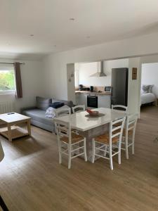 a kitchen and living room with a table and chairs at gîte du parc du moulin du pré in Bavent