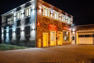 uma rua vazia em frente a um edifício de tijolos à noite em Motelik Janowski em Szprotawa